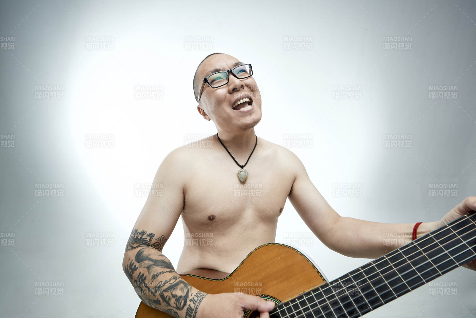 示范演奏古典吉他的亚洲男性乐手人像图片