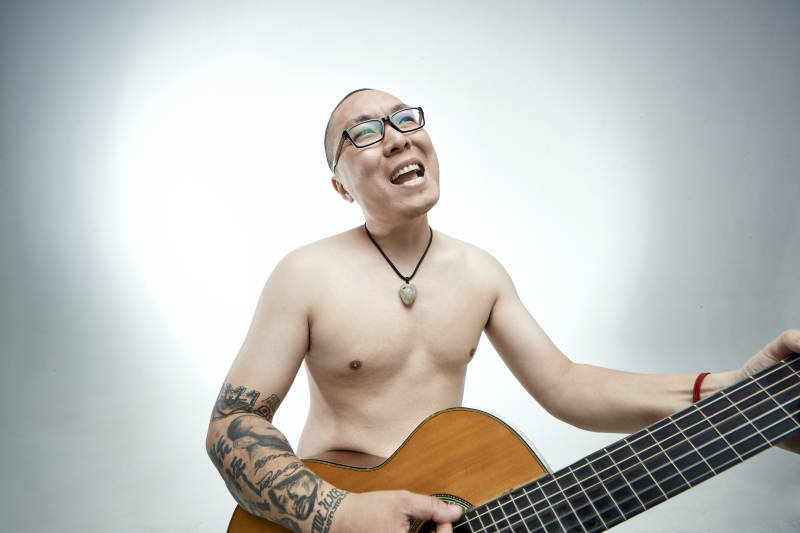 示范演奏古典吉他的亚洲男性乐手人像图片