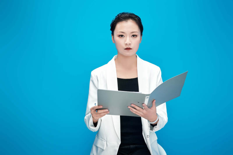 身穿西服拿着手机与文件夹的亚洲商务女士图片