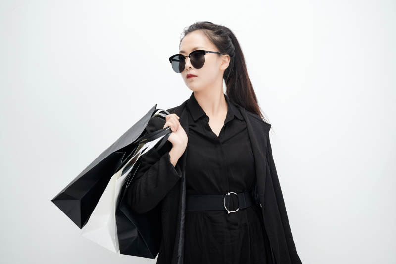 白色背景下手提购物袋时尚美丽的亚洲少女图片