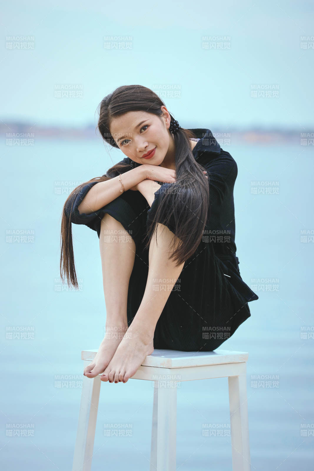 悠闲的坐在美丽湖岸码头的亚洲年轻女性人像图片