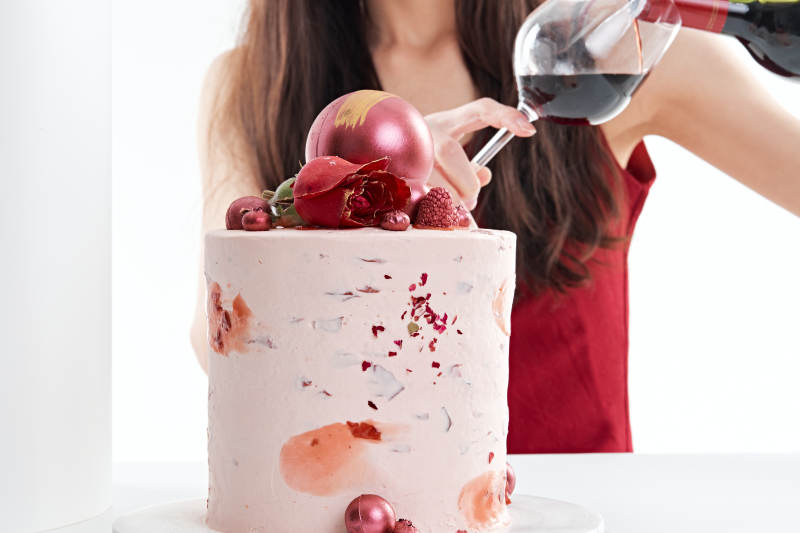 喝红酒品尝蛋糕的年轻女性图片