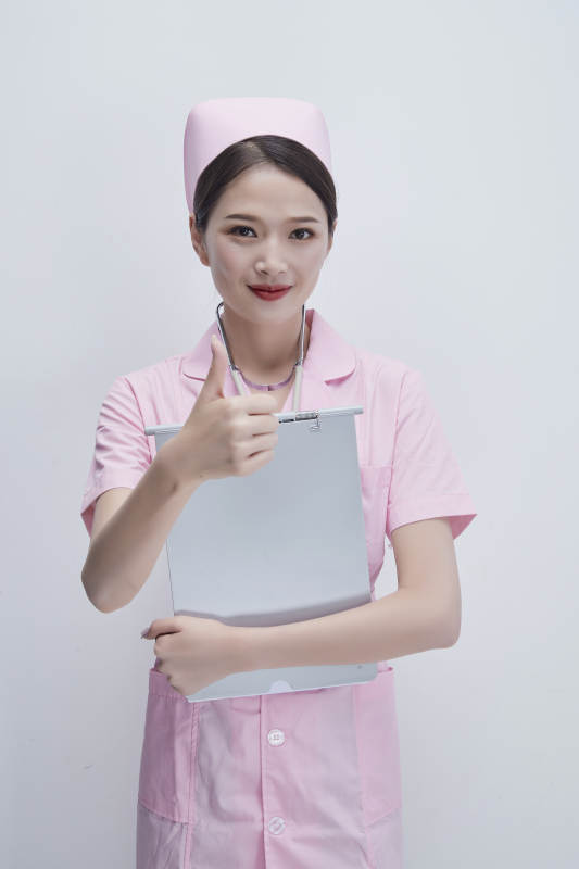 穿粉色护士服戴听诊器手持病历夹的医护人员图片
