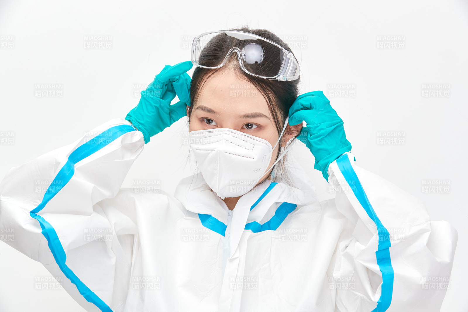 穿白色防护服佩戴护目镜口罩的女性医疗人员图片