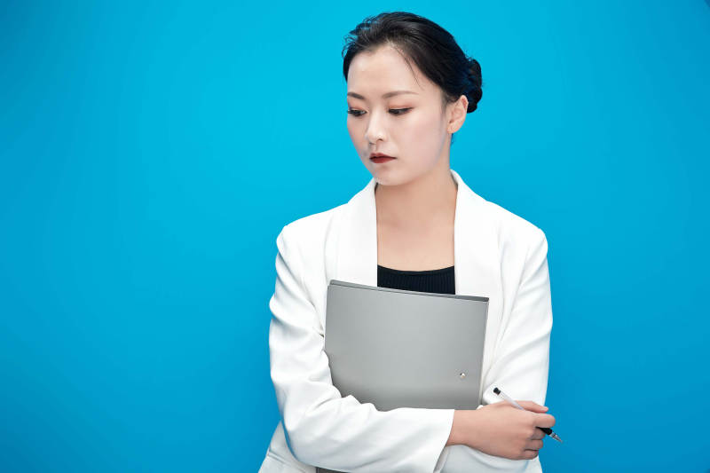 身穿西服拿着手机与文件夹的亚洲商务女士图片