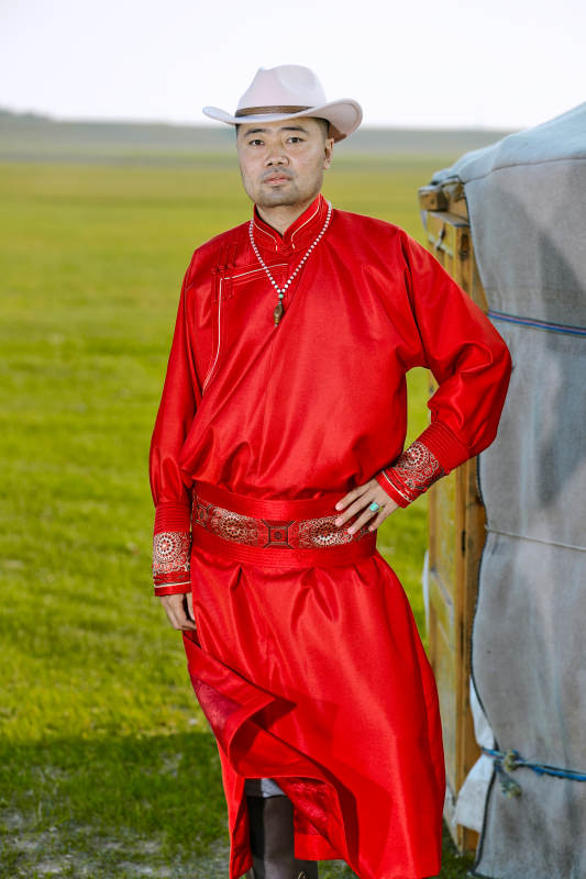 草原上蒙古包前身穿蒙古族传统服饰的男子图片