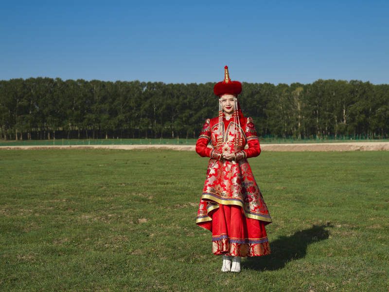 草原上穿着蒙古族传统服饰的亚洲年轻美少女图片