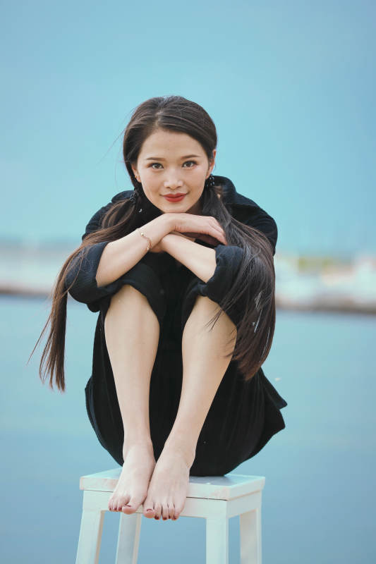 悠闲的坐在美丽湖岸码头的亚洲年轻女性人像图片