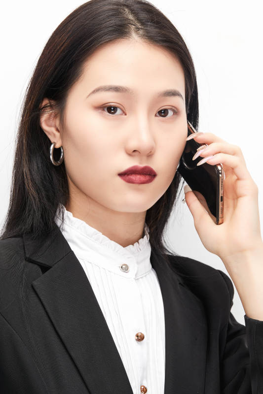 身穿西服拿着手机的美丽商务女士图片