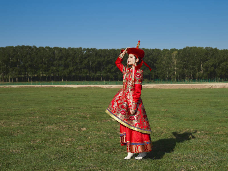 草原上穿着蒙古族传统服饰的亚洲年轻美少女图片