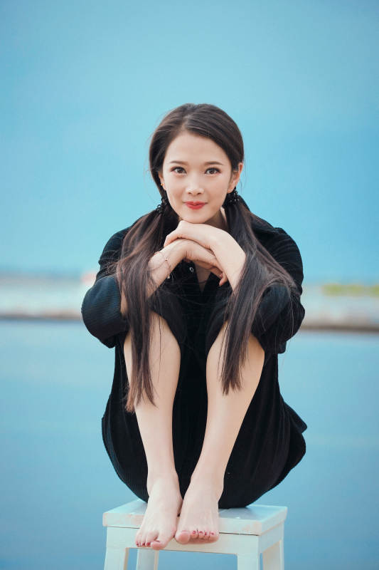 悠闲的坐在美丽湖岸码头的亚洲年轻女性人像图片