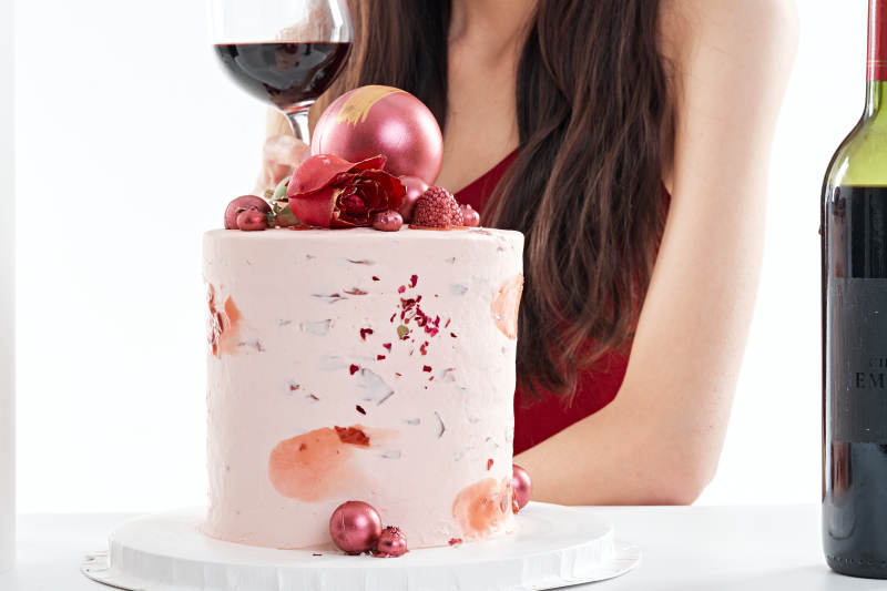 喝红酒品尝蛋糕的年轻女性图片