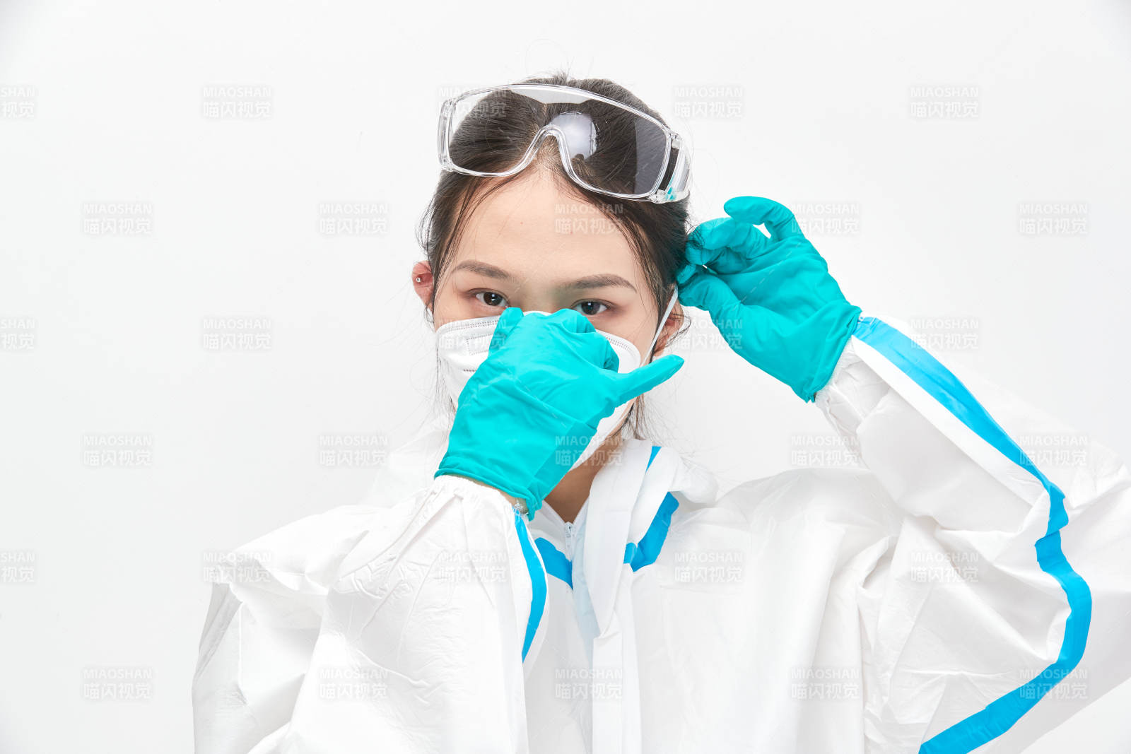 穿白色防护服佩戴护目镜口罩的女性医疗人员图片
