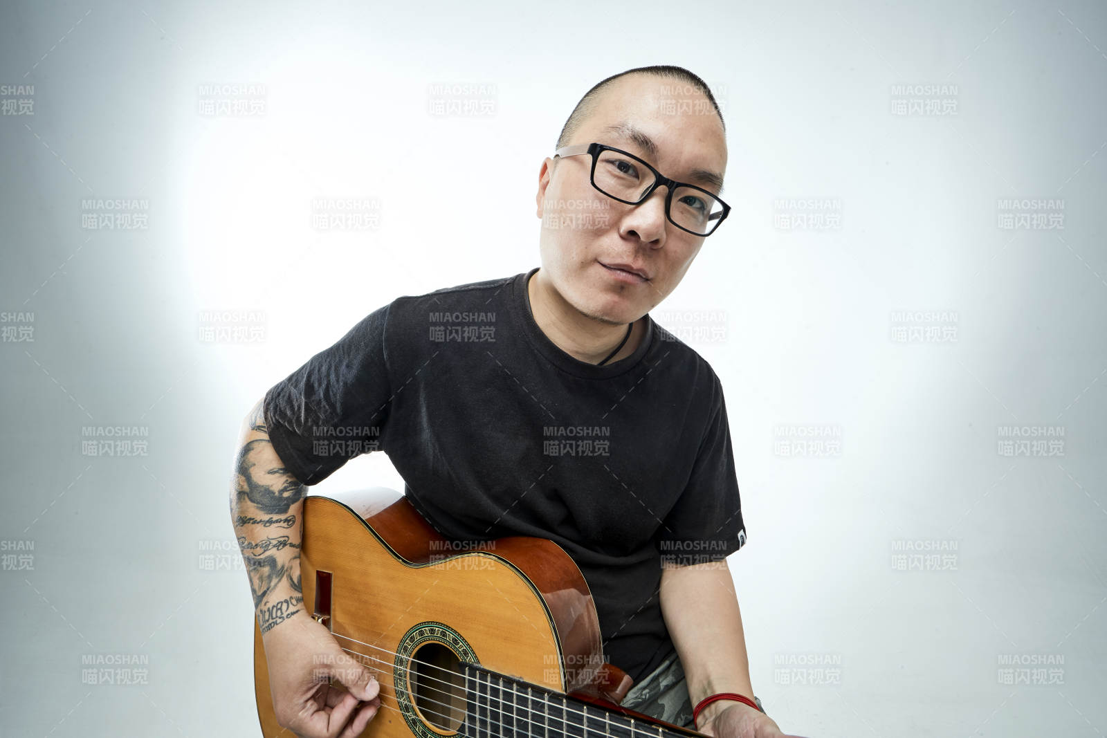 示范演奏古典吉他的亚洲男性乐手人像图片