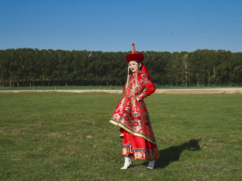 草原上穿着蒙古族传统服饰的亚洲年轻美少女图片