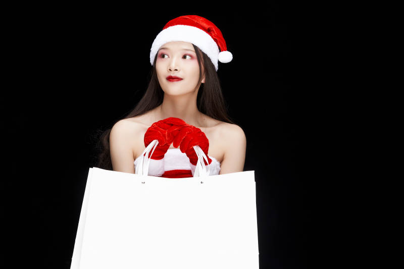 身穿圣诞服饰手提购物袋性感可爱的圣诞女郎图片
