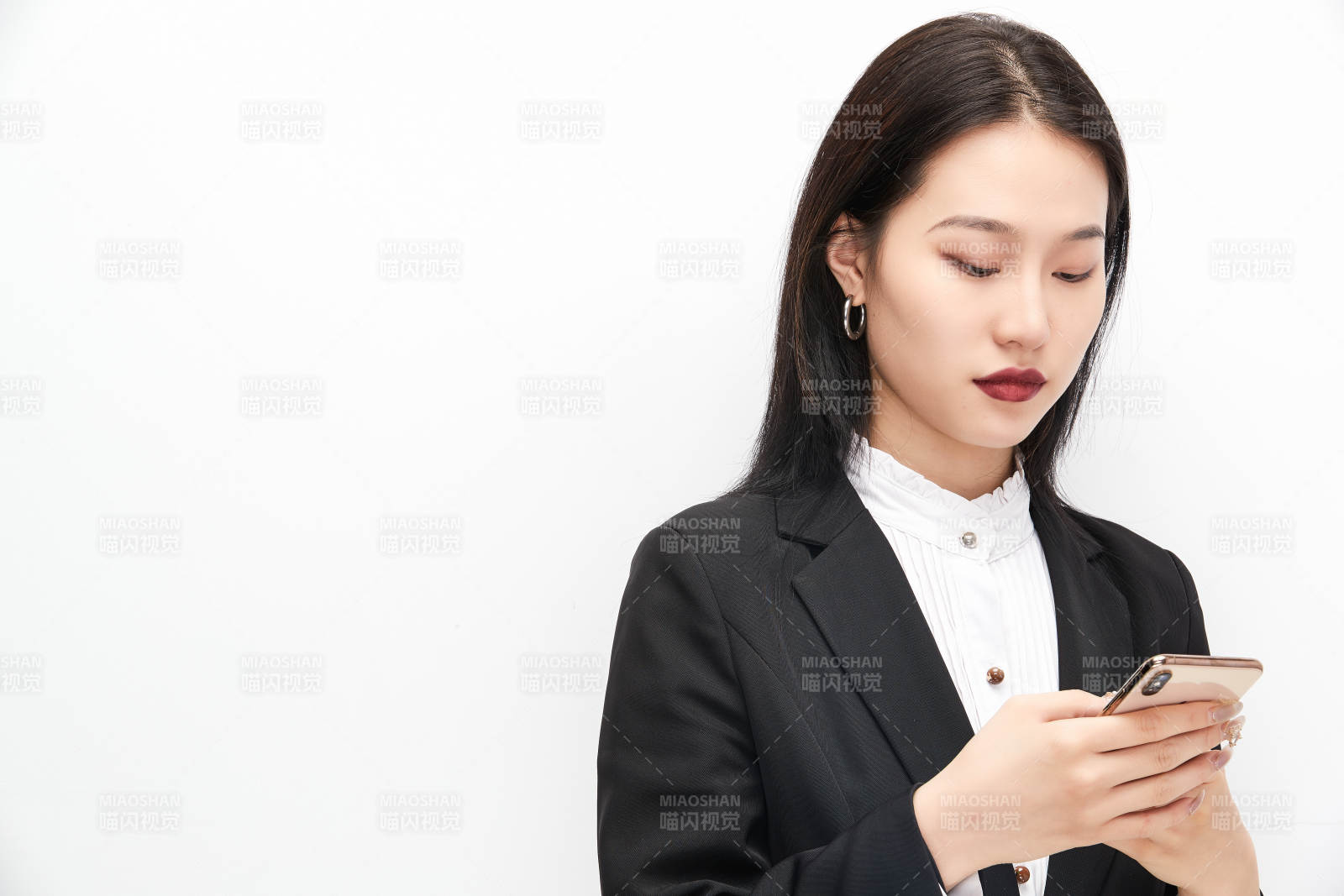 身穿西服拿着手机的美丽商务女士图片