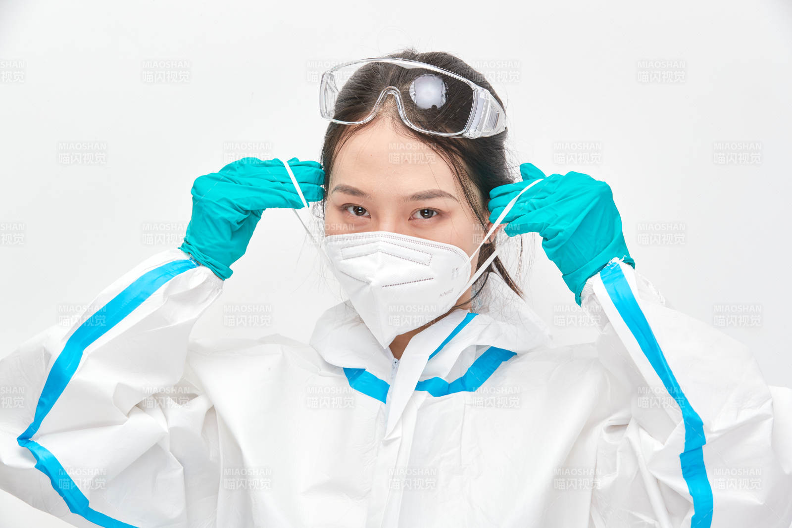 穿白色防护服佩戴护目镜口罩的女性医疗人员图片