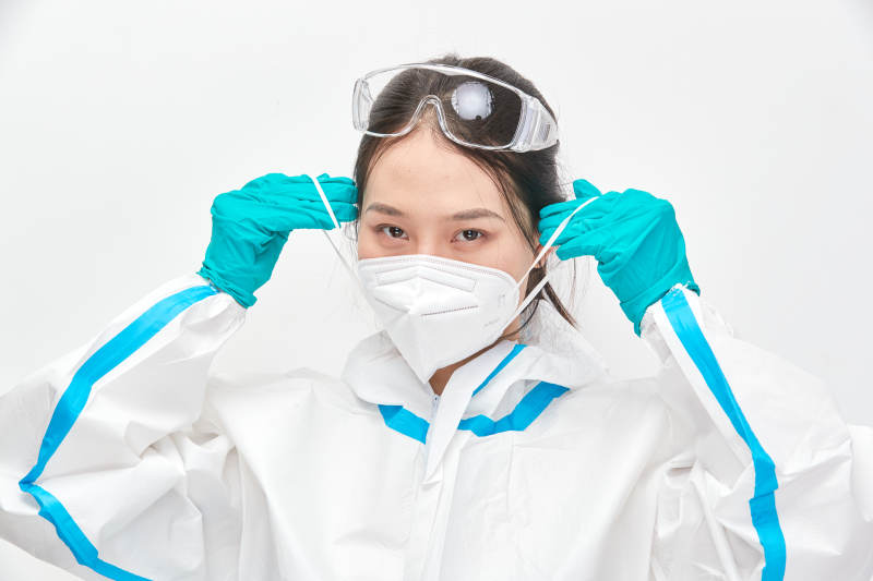 穿白色防护服佩戴护目镜口罩的女性医疗人员图片
