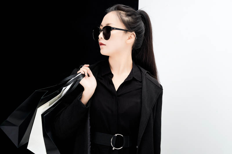 黑白色背景下的手提购物袋的时尚亚洲少女图片