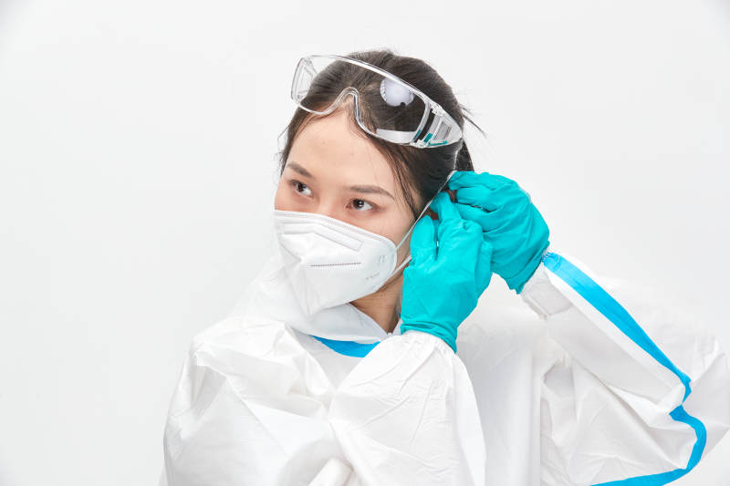 穿白色防护服佩戴护目镜口罩的女性医疗人员图片