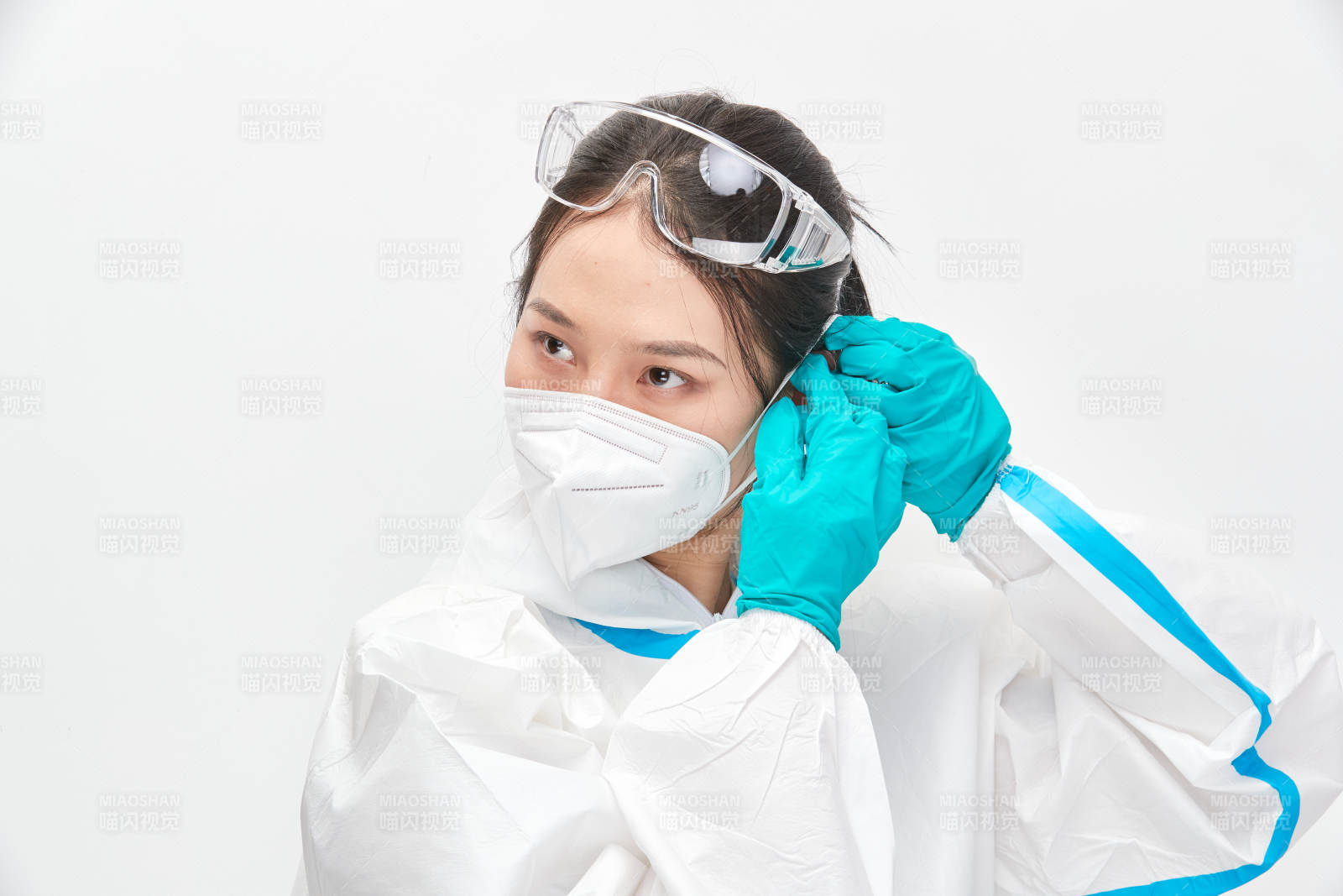 穿白色防护服佩戴护目镜口罩的女性医疗人员图片