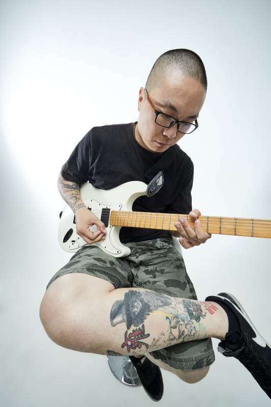 手持电吉他展示演奏的亚洲男性摇滚乐手人像图片