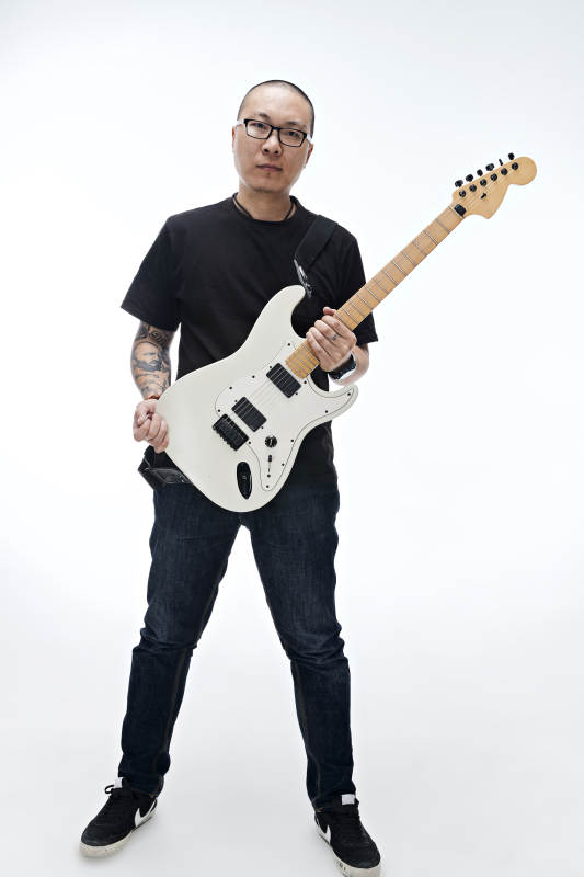 手持电吉他展示演奏的亚洲男性摇滚乐手人像图片