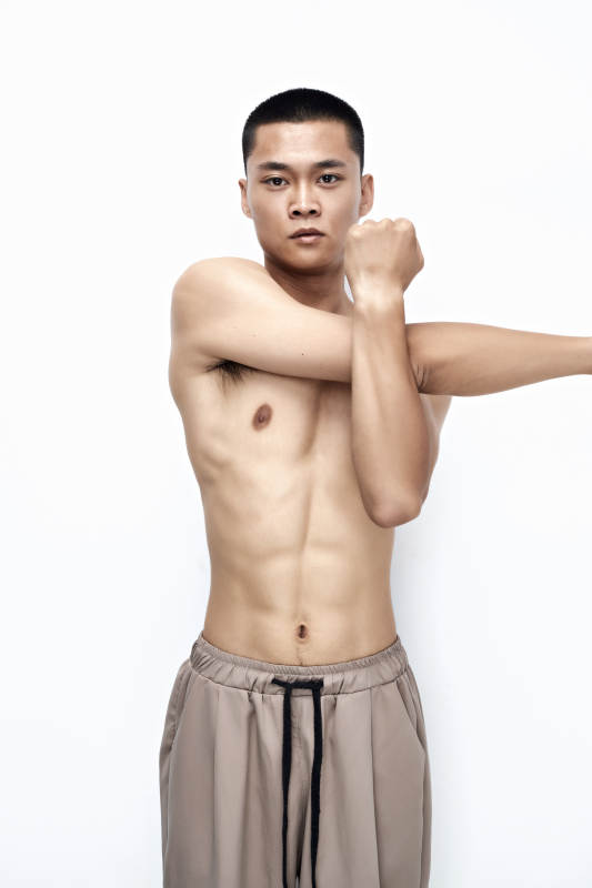 白色背景下展示健身预备拉伸动作的亚洲男性图片