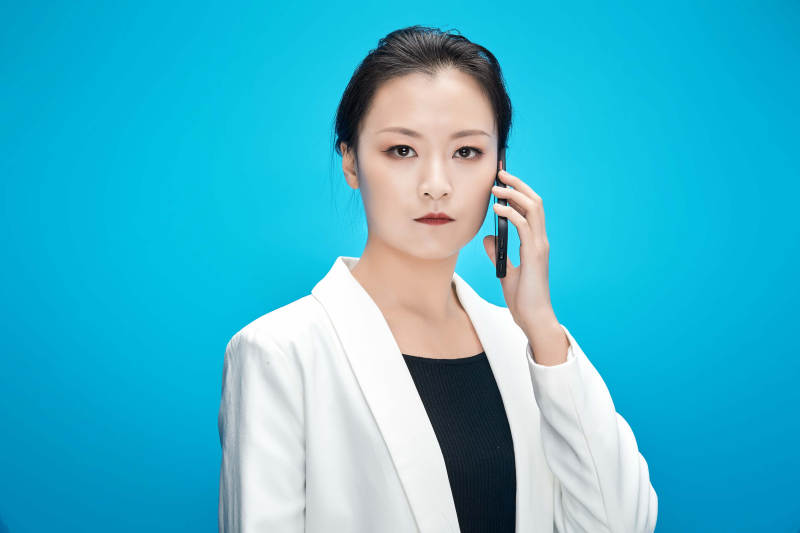 身穿西服拿着手机与文件夹的亚洲商务女士图片