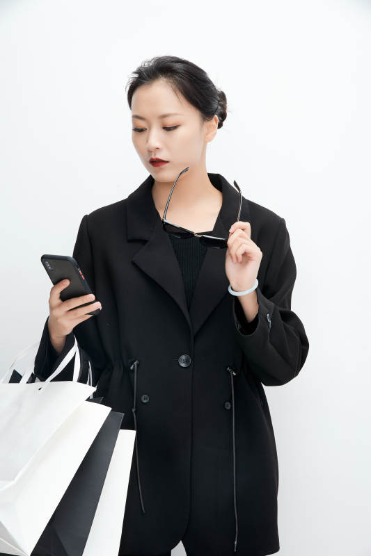 白色背景下手提购物袋时尚美丽的亚洲少女图片