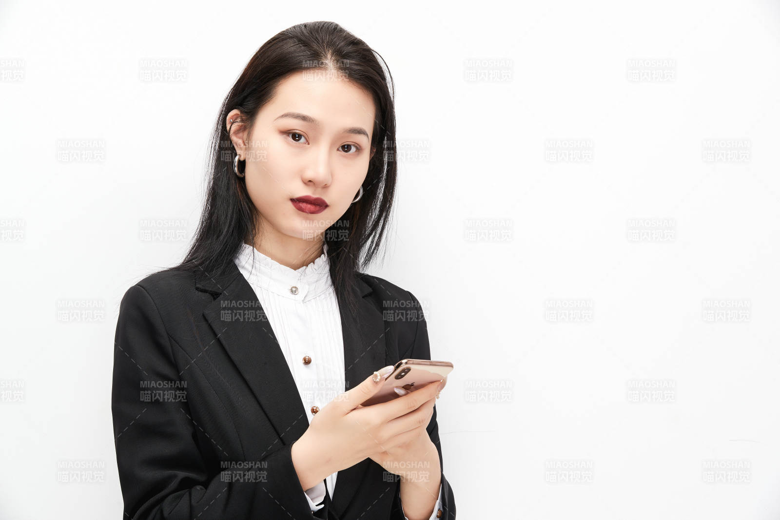 身穿西服拿着手机的美丽商务女士图片