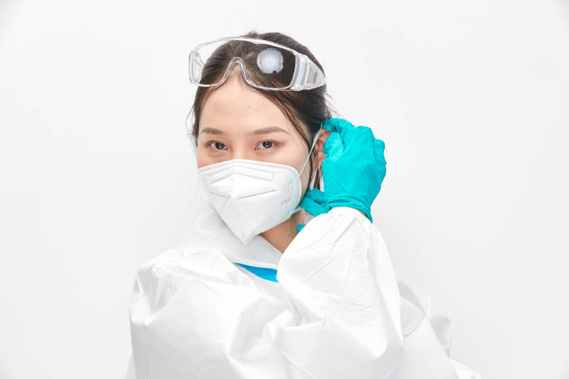 穿白色防护服佩戴护目镜口罩的女性医疗人员图片