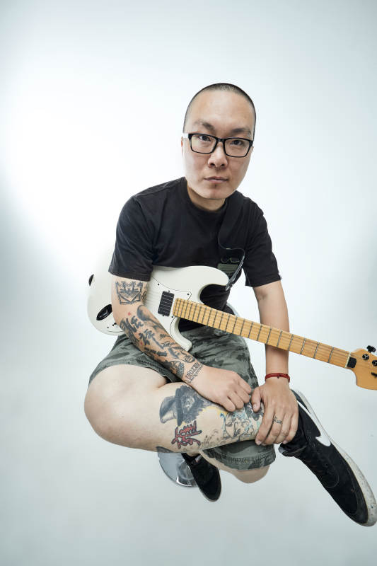 手持电吉他展示演奏的亚洲男性摇滚乐手人像图片