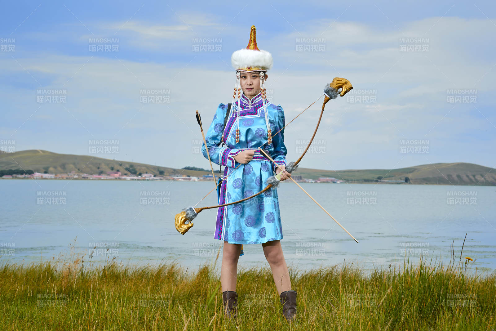 草原湖畔身穿蒙古族饰手持弓箭的蒙族少女图片