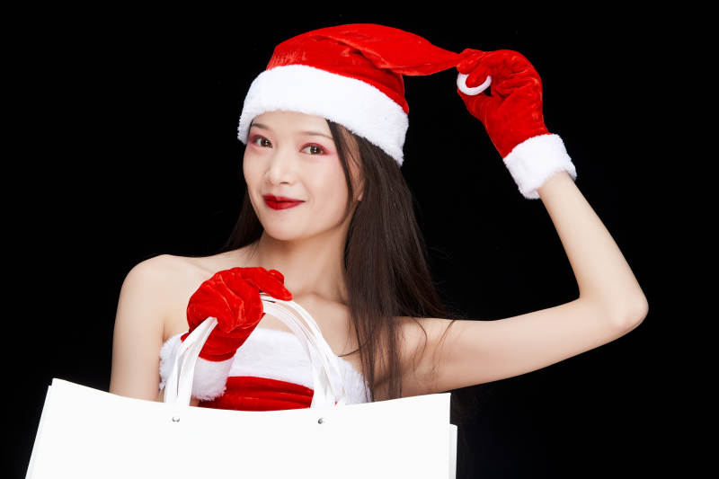 身穿圣诞服饰手提购物袋性感可爱的圣诞女郎图片