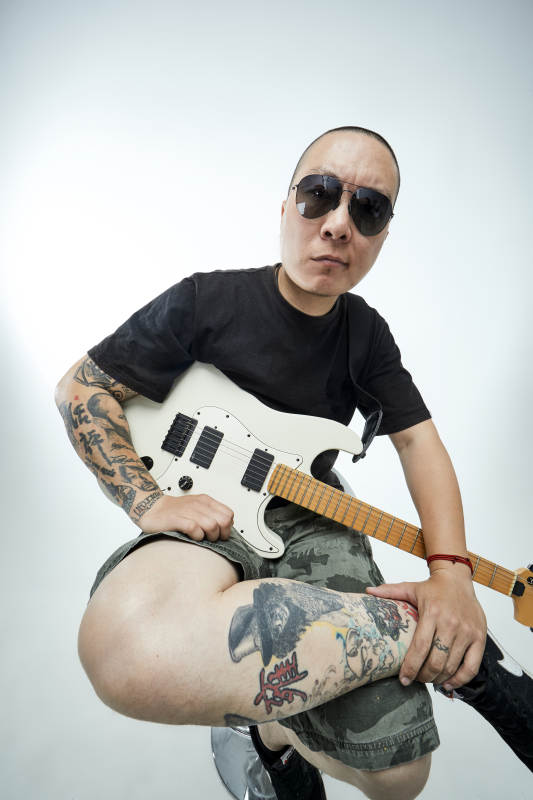 手持电吉他展示演奏的亚洲男性摇滚乐手人像图片