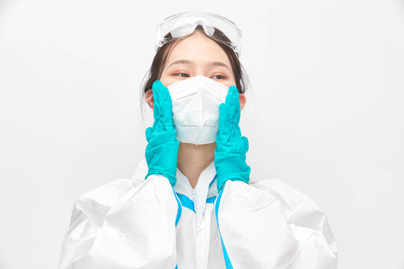 穿白色防护服佩戴护目镜口罩的女性医疗人员图片