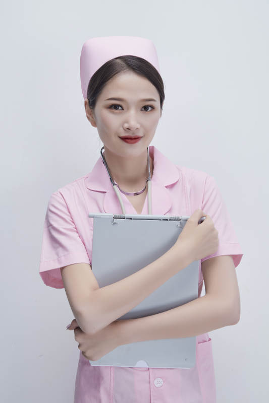 穿粉色护士服戴听诊器手持病历夹的医护人员图片