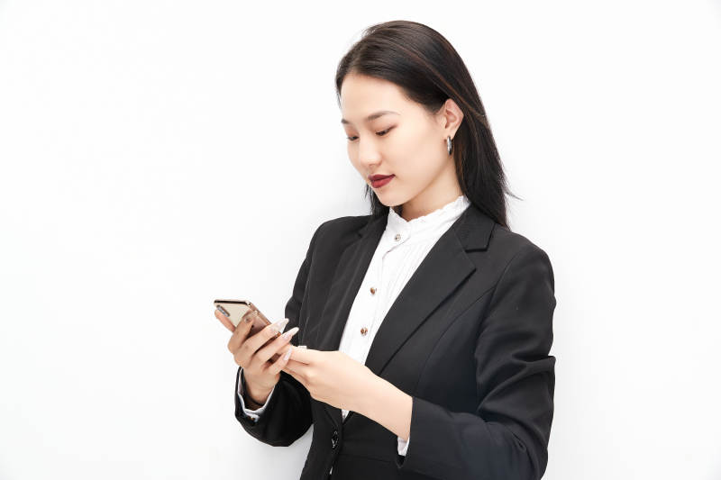 身穿西服拿着手机的美丽商务女士图片