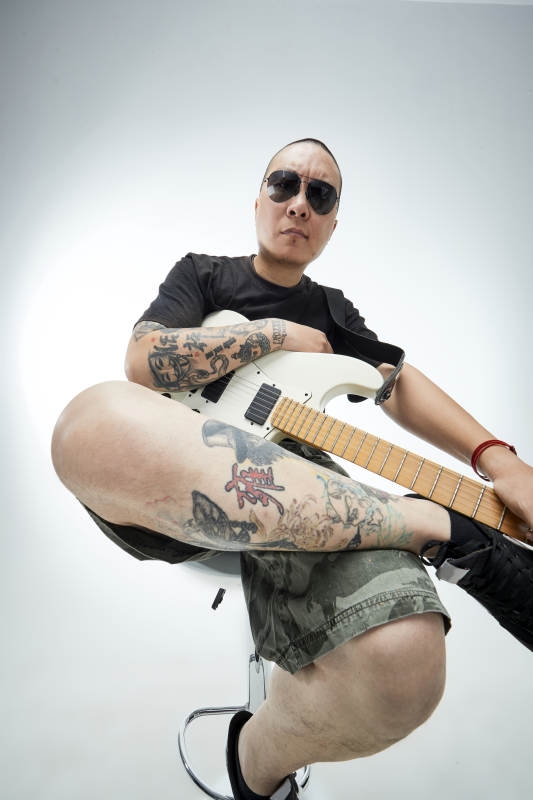 手持电吉他展示演奏的亚洲男性摇滚乐手人像图片