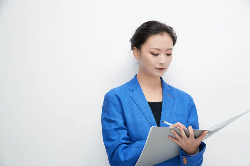 白色背景下拿着文件夹的美丽商务女士图片