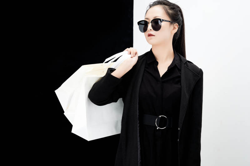 黑白色背景下的手提购物袋的时尚亚洲少女图片