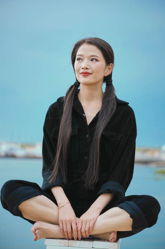 悠闲的坐在美丽湖岸码头的亚洲年轻女性人像图片