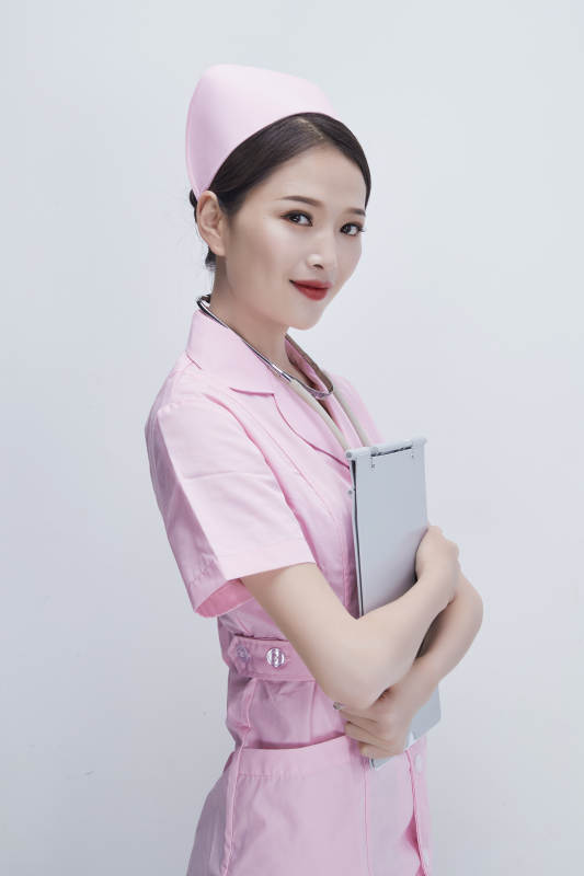 穿粉色护士服戴听诊器手持病历夹的医护人员图片