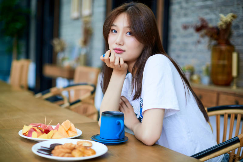 坐在咖啡图书馆吃东西的可爱少女图片