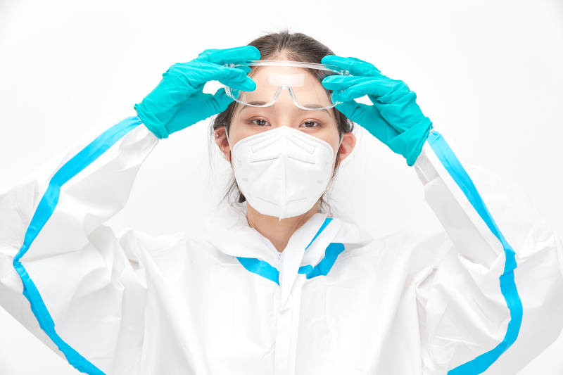 穿白色防护服佩戴护目镜口罩的女性医疗人员图片