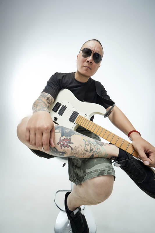 手持电吉他展示演奏的亚洲男性摇滚乐手人像图片