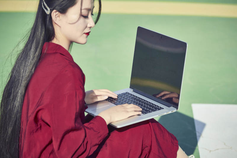 户外进行商务办公的青年女性局部特写图片