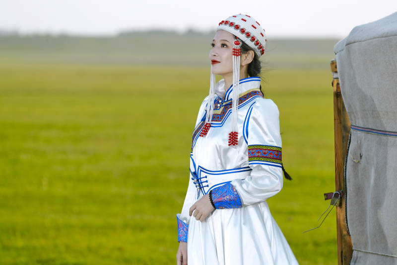 草原上穿着蒙古族传统服饰的亚洲年轻美少女图片